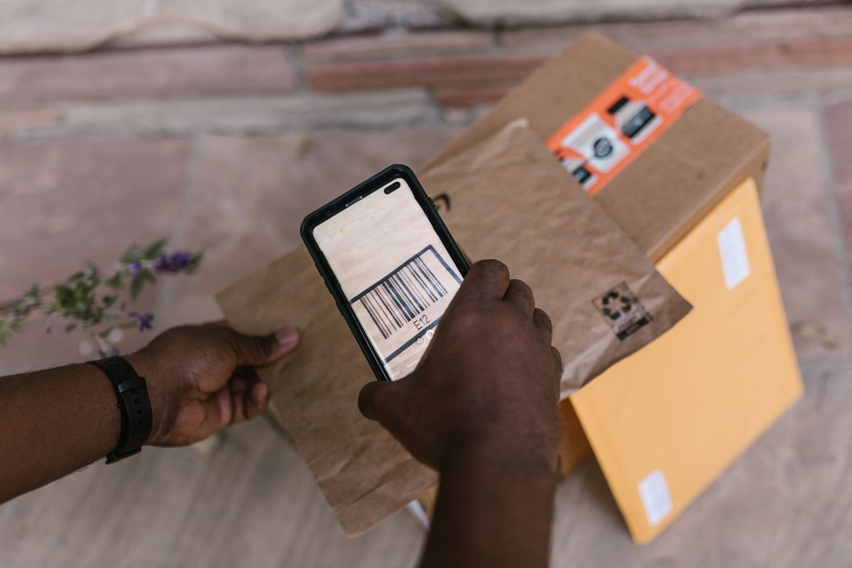 Courier scanning the barcode on a parcel with a smartphone