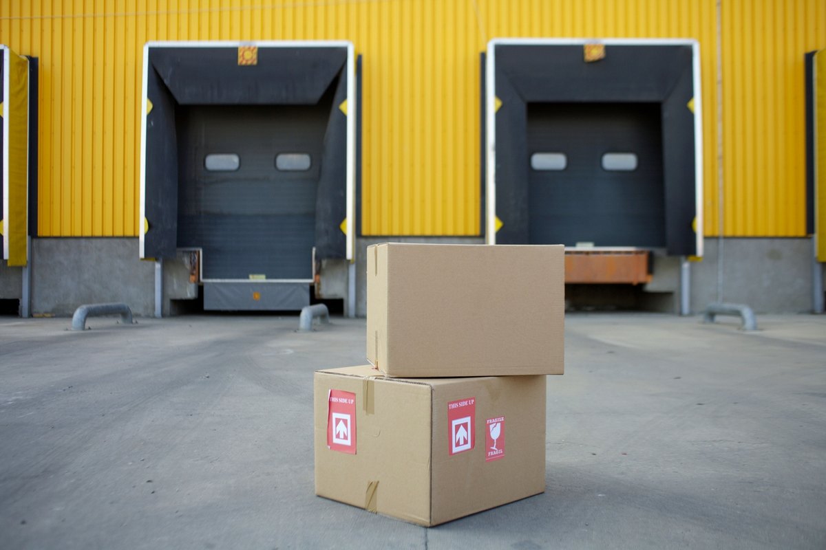Two taped cardboard boxes in front of closed yellow loading dock doors